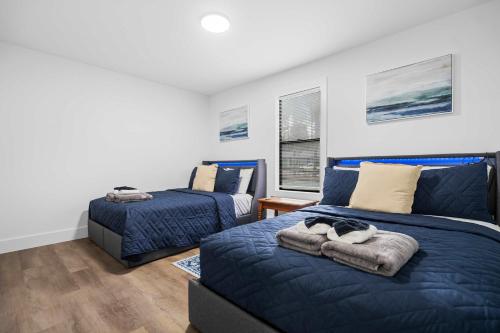 a bedroom with two beds and a blue bed at 8 Minutes to UNC - Outdoor Deck - Washer and Dryer in Chapel Hill
