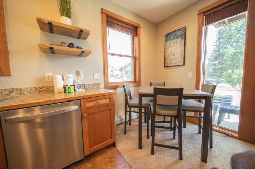 a kitchen and dining room with a table and chairs at Antlers Gulch 106 by SummitCove Lodging in Colorado in Keystone