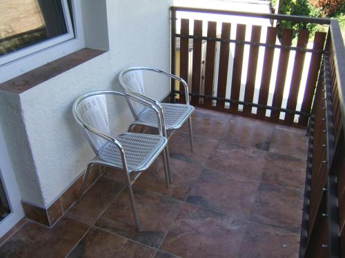 two chairs sitting on a balcony next to a fence at Penzion V Roklich & Apartments V Roklich in Ricany