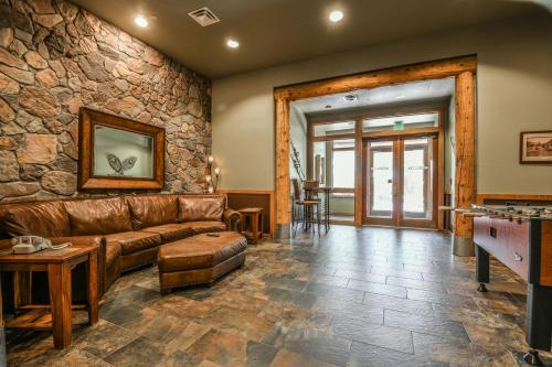 a living room with a couch and a stone wall at Arapahoe Lodge 8105 by SummitCove Lodging in Keystone