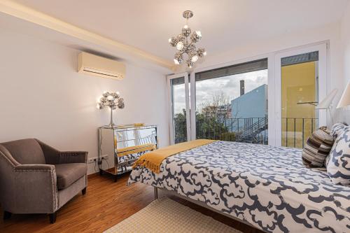 a bedroom with a bed and a chair and a window at Barbadinhos Apartments in Lisbon Historic Neighborhood in Lisbon