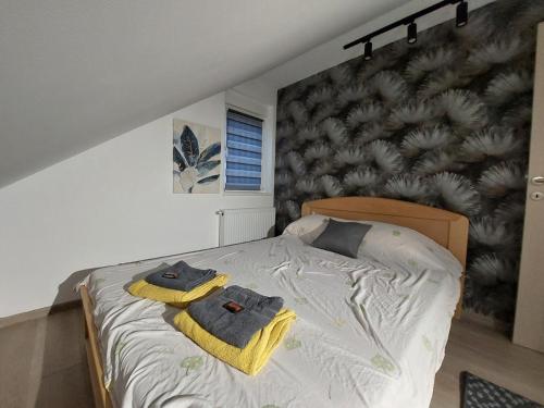 a bedroom with a bed with towels on it at Oaza Apartmani Jakovo HERA in Jakovo