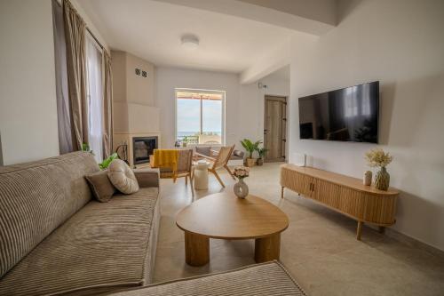 a living room with a couch and a table at Golden Horizon seafront in Goúdhouros