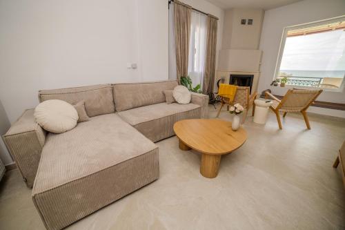 a living room with a couch and a table at Golden Horizon seafront in Goúdhouros