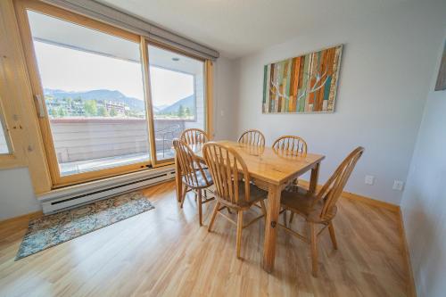 a dining room with a table and chairs and a large window at Argentine 1504 by SummitCove Lodging in Colorado in Keystone