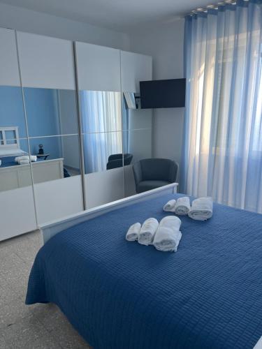 a bedroom with a blue bed with towels on it at Ambra Holiday House in Furore