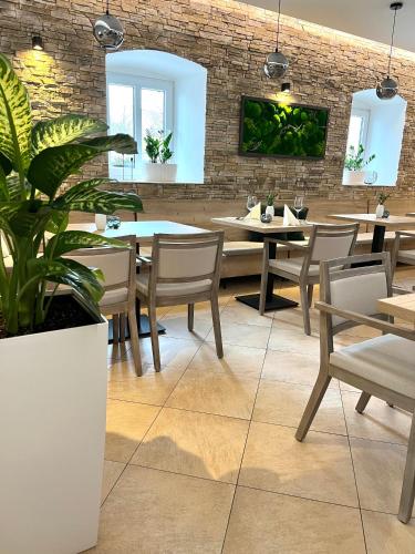 a restaurant with tables and chairs and a brick wall at Penzion Sen in Černá v Pošumaví