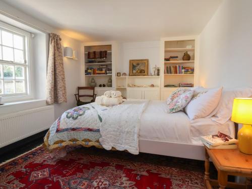 a bedroom with a bed and a desk and a window at Blackbird Cottage near Appledore in Bideford
