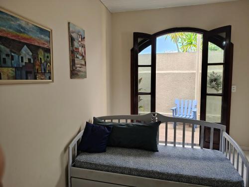 a crib in a room with a window at Oásis - Casa com Piscina e Churrasqueira in Pontal do Paraná