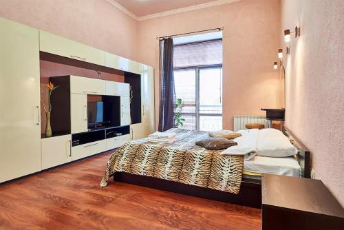 - une chambre avec un grand lit et une grande télévision dans l'établissement Home Hotel Apartments on Zoloti Vorota, à Kiev
