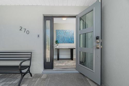 a door to a room with a bench and a table at Villa Tranquility-Waterfront-Free Amenities-Heated Pool-Bikes-Dock Fishing & Beach Gear in Punta Gorda