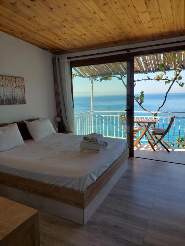 a bedroom with a bed and a view of the ocean at Qeparo Antonio Rooms in Qeparo