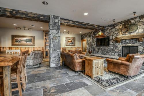 a bar with leather furniture and a stone wall at Black Bear 8035 by SummitCove Lodging in Keystone