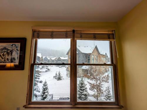 a window with a view of a snow covered yard at Black Bear 8035 by SummitCove Lodging in Keystone