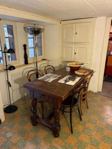 a dining room with a wooden table and chairs at Le refuge boisé in Hérémence