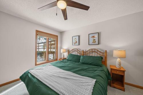 a bedroom with a green bed with a ceiling fan at Oma's Beech House in Beech Mountain