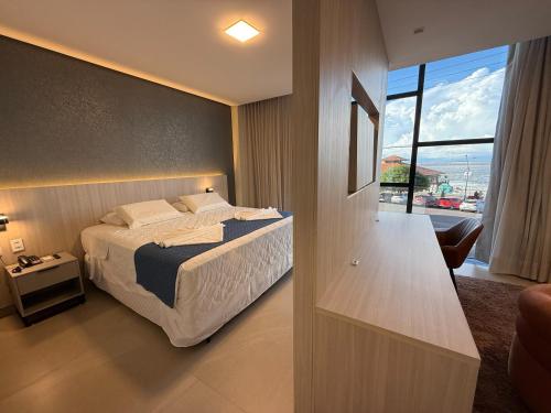 a bedroom with a bed and a view of the ocean at Hotel London Santarem in Santarém