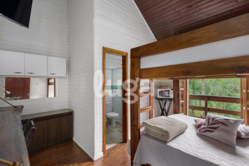 a bedroom with a bed and a bathroom with a window at Suite Left – Cyclists' Paradise in Gramado