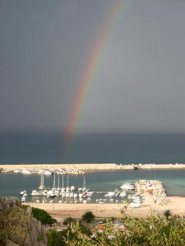 a rainbow over a beach with a marina with boats at I Segreti di Antonina in Castelluzzo