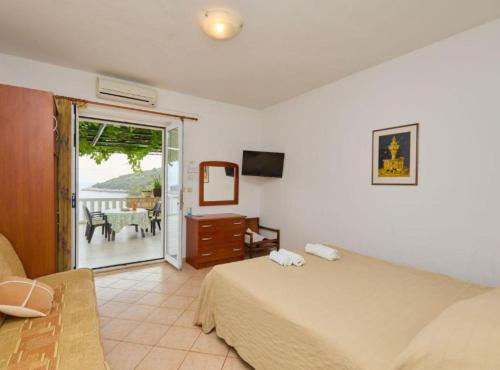 a bedroom with a bed and a view of a patio at Villa Azure Saplunara in Saplunara