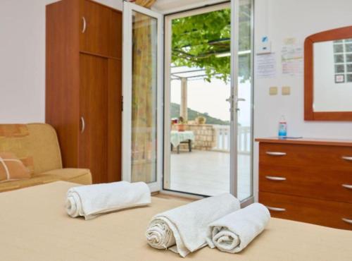 a bedroom with towels on a bed with a sliding glass door at Villa Azure Saplunara in Saplunara