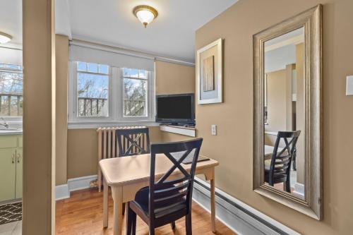 a dining room with a table and chairs and a mirror at Chic Midstream Studio WiFi Parking in St. John's