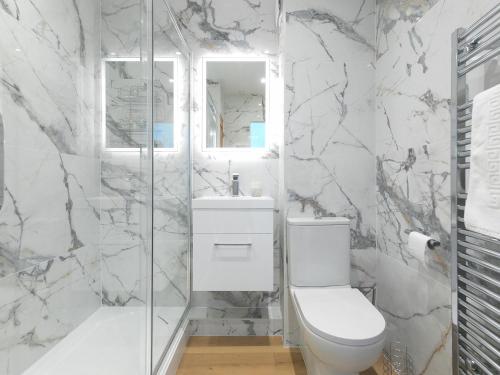 a white bathroom with a toilet and a shower at Millies in St Ives