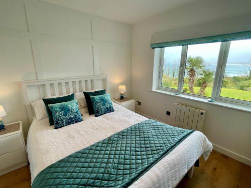 a bedroom with a bed and a large window at Millies in St Ives