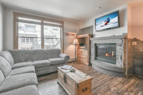 a living room with a couch and a fireplace at Black Bear 8052 by SummitCove Lodging in Keystone