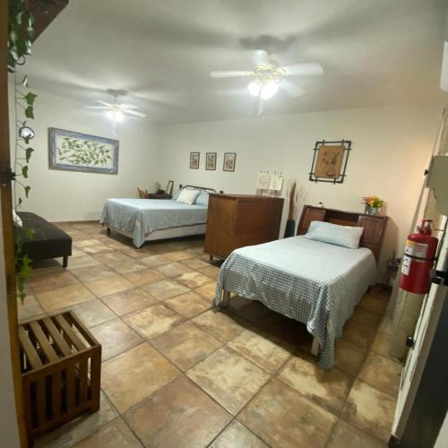 a room with two beds and a ceiling fan at Finca El Fraile in Monterrey