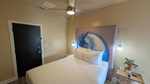 a bedroom with a bed with a painting on the wall at The Crescent Hotel Beverly Hills in Los Angeles