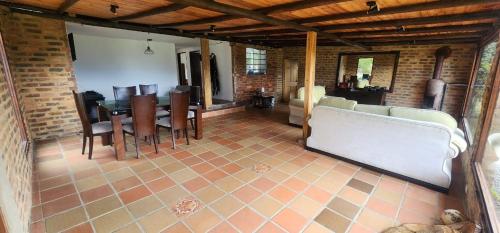 a living room with a couch and a table and chairs at Finca El Recuerdo in Guatavita