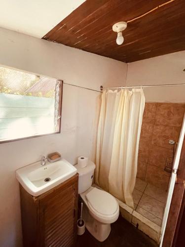 a bathroom with a toilet and a sink at Noni garden apartment in Tamarindo