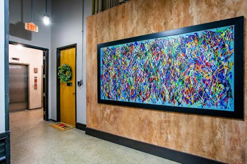 a large television on a wall in a hallway at Modern Downtown Loft - 1 mile to UT in Knoxville