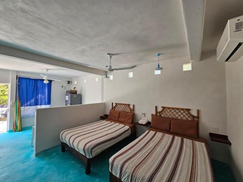a room with two beds in it with a window at Alojamiento Turquesa in Barrio Nuevo