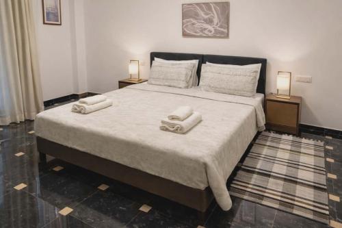 ein Schlafzimmer mit einem großen Bett, auf dem zwei Handtücher liegen in der Unterkunft Pasithea's Apartment in Samos