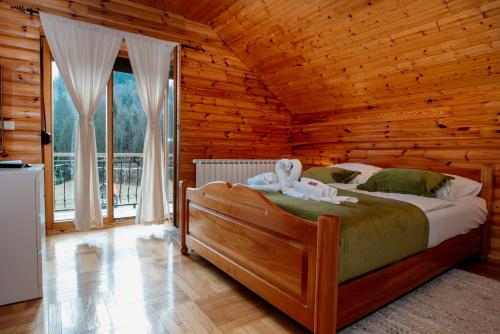 a bedroom with a bed in a log cabin at Greenhouse Klara with heated pool in Tršće