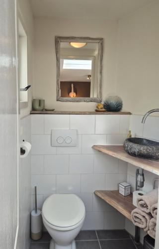 a bathroom with a toilet and a fire in the mirror at Zandvoort Beach Escape 2P in Zandvoort