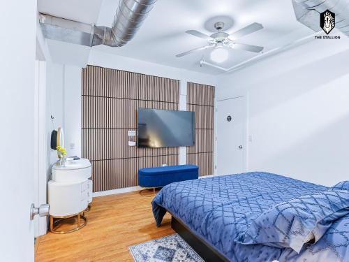 a bedroom with a blue bed and a flat screen tv at The Stallion in Memphis