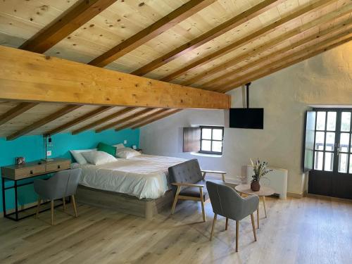 a bedroom with a bed and a desk and chairs at Gautegiz Arteaga Reserva Urdaibai in Isla Becoa