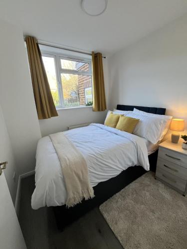 a bedroom with a large bed with a window at Two Bedroom Flat Bristol in Shirehampton