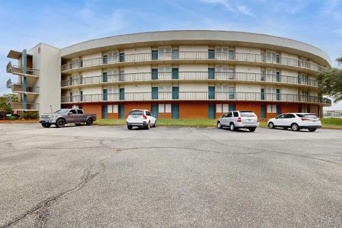 a large building with cars parked in front of it at Coastal condo with shared pool beaches shopping in Fort Walton Beach