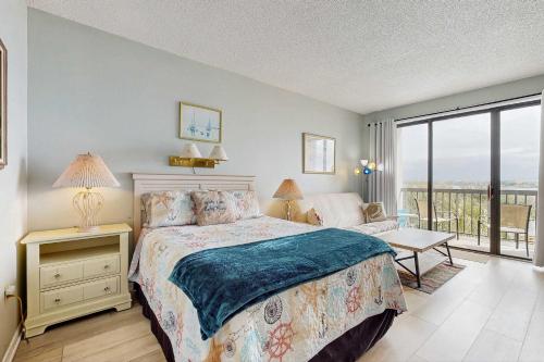 a bedroom with a bed and a balcony at Coastal condo with shared pool beaches shopping in Fort Walton Beach