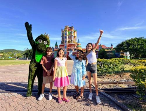 a group of children standing next to a frog statue at Hotel Recanto dos Dinossauros in Penha
