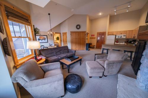 a living room with couches and chairs and a kitchen at Buffalo Lodge 8411 by SummitCove Lodging in Colorado in Keystone