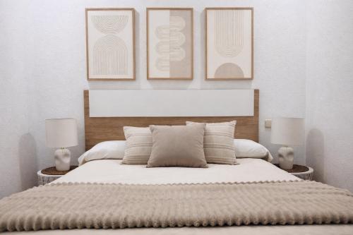 a bedroom with a bed with three pictures on the wall at Sa Tuna - Delta de l'Ebre in Riumar