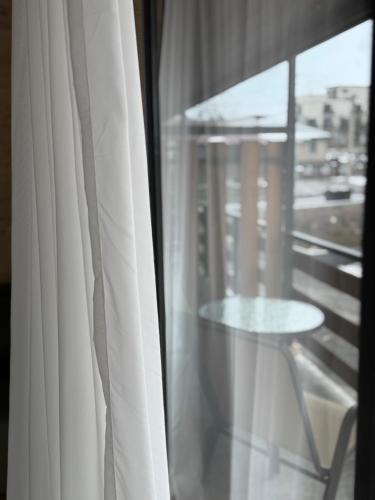 a glass window with a table and a view of a city at Tetri Jikhvi in Kazbegi