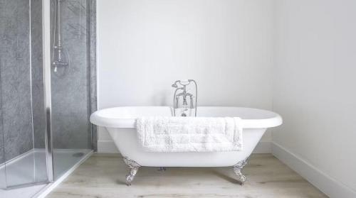 a white bath tub in a bathroom with a shower at Whitecraigs in Elgin