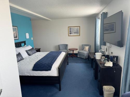 a hotel room with a bed and a tv at Wilshireinn Hotel in Claresholm