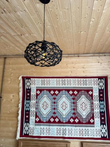 a rug hanging from a ceiling with a chandelier at Tetri Jikhvi in Kazbegi
